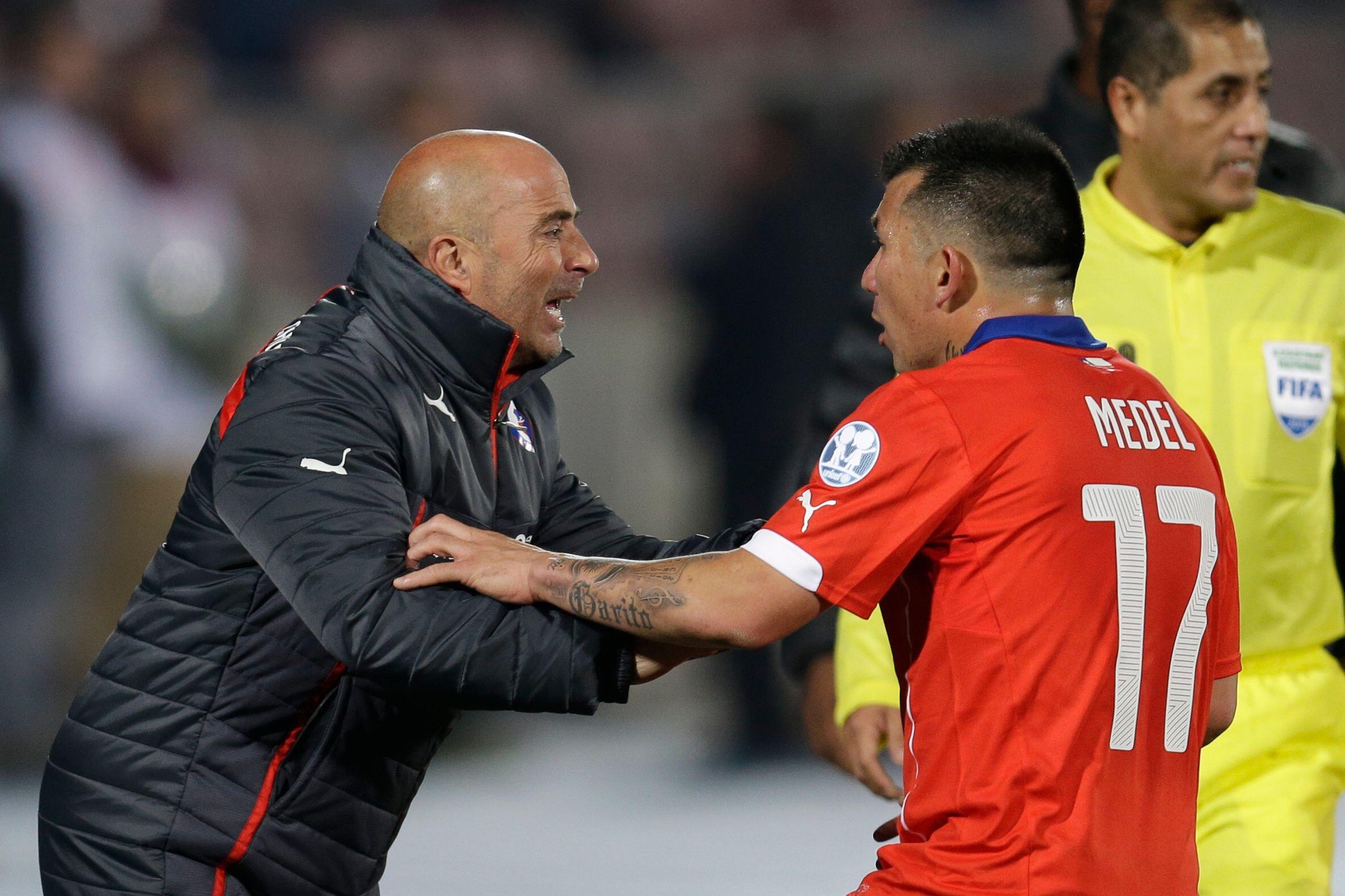 Chile's coach Jorge Sampaoli, left, talks to Chile's Gary Medel during a Copa America Group A soccer match against Mexico at El Nacional stadium in Santiago, Chile, Monday, June 15, 2015. (AP Photo/Natacha Pisarenko)