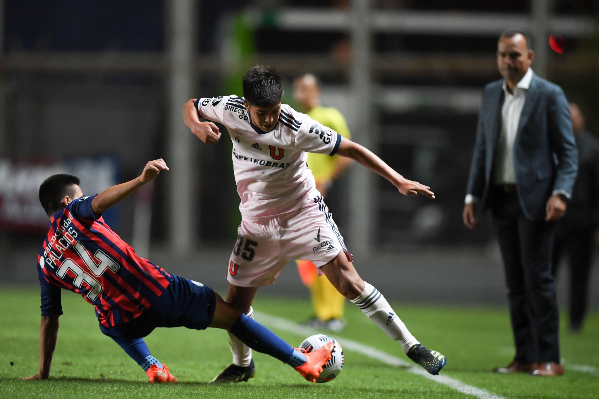 Marcelo Morales of Universidad de Chile, right, and Julián Palacios of Argentina's San Lorenzo battle for the ball during a Copa Libertadores soccer match in Buenos Aires, Argentina, Wednesday, March 17, 2021.(Ronaldo Schemidt/Pool via AP)