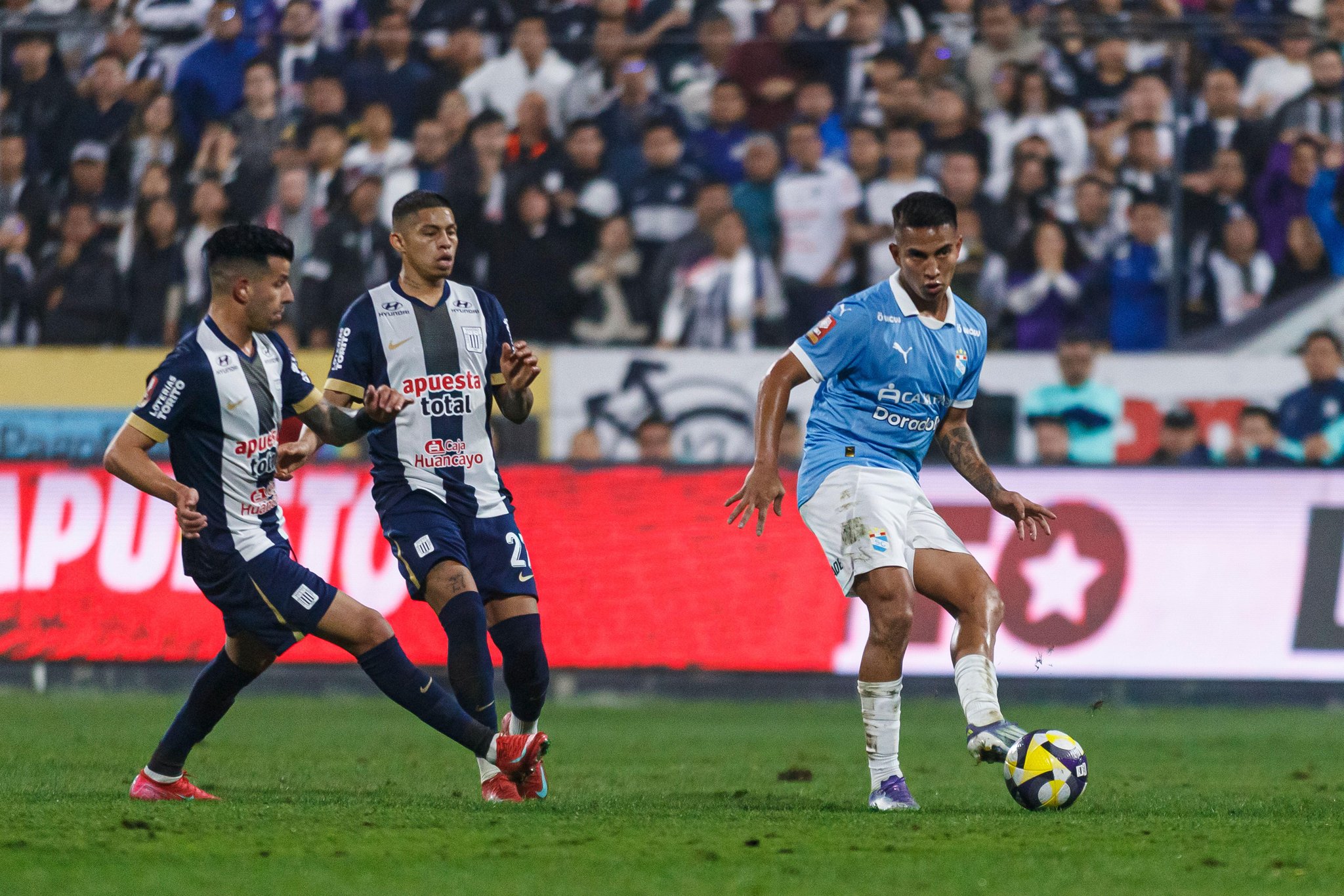 Lima, Peru - August 5: Martin Tavara of Sporting Cristal (R) passes the ball during a Liga 1 Peru match between Alianza Lima and Sporting Cristal at E